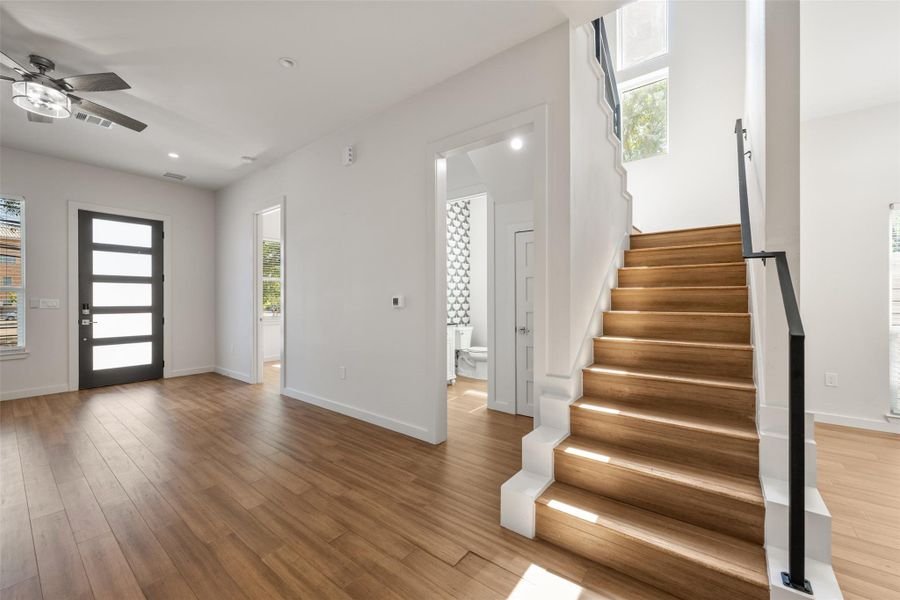 Foyer entrance featuring healthy amount of natural light, stairway, wood finished floors, ceiling fan, and recessed lighting