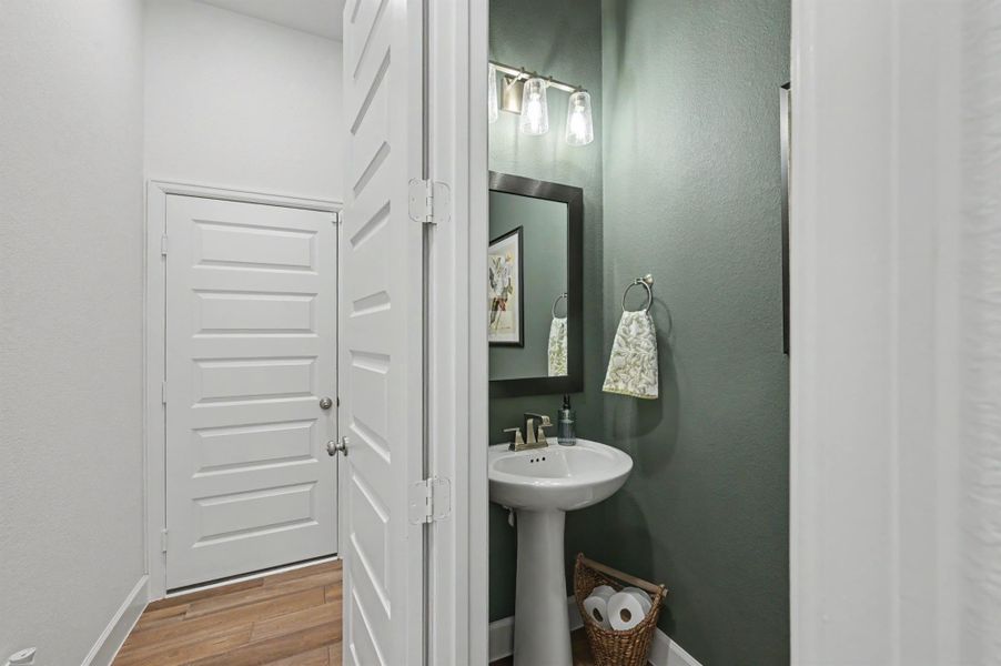 The hallway to the right of the media room has a half bath which is convenient for guests. There are six panel doors throughout and this door leads to the garage. The hallway to the right of the media room has a half bath which is convenient for guests. There are six panel doors throughout and this door leads to the garage.