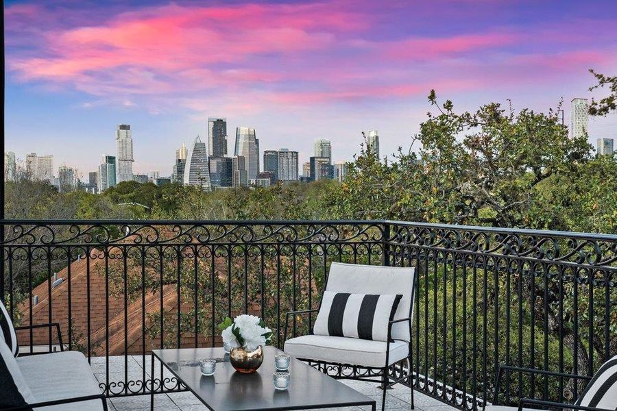 Balcony at dusk with a view of skyline