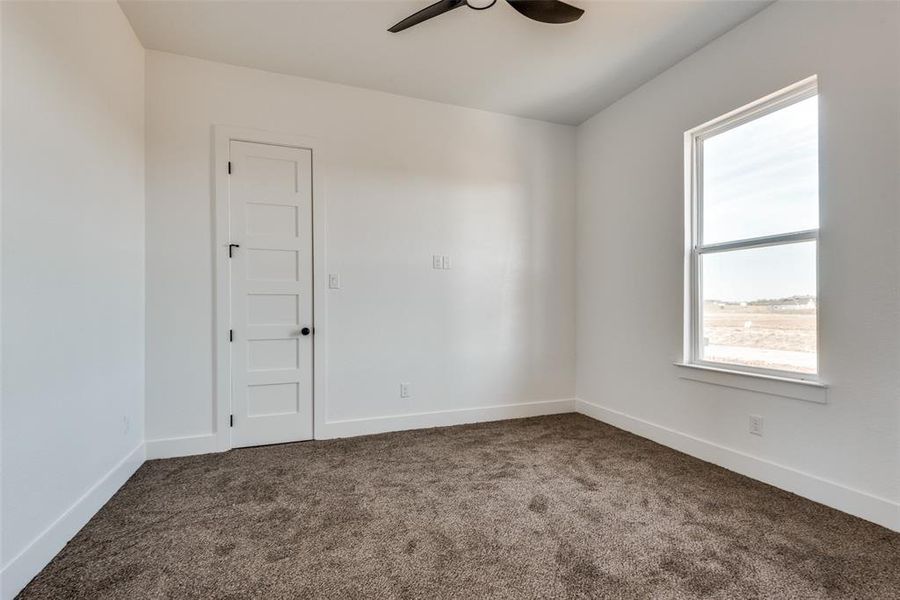 Carpeted empty room featuring ceiling fan