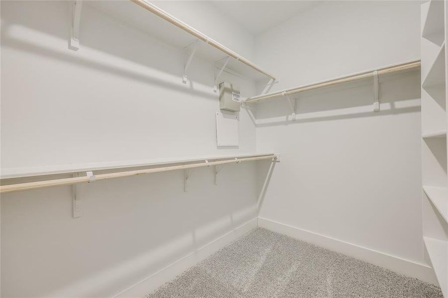 Large closet with built in shelving and lots of room for hanging items.