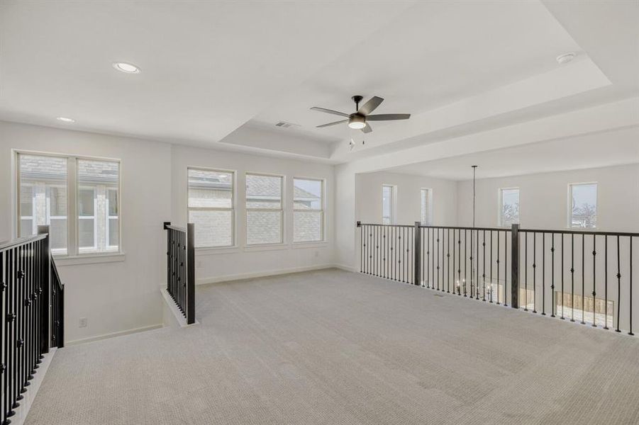 Spare room featuring a ceiling fan, carpet flooring, a tray ceiling, and recessed lighting