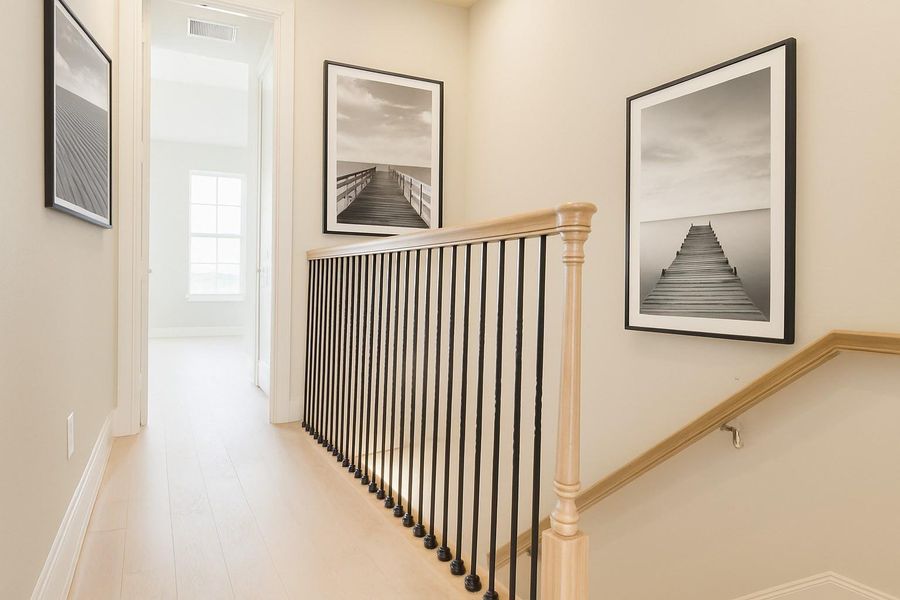 Elegant metal spindles enhance the look of the third-floor hallway.   Virtual artwork added.