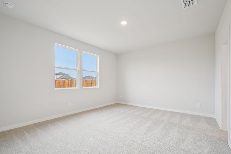 A room with a window and a white wall.