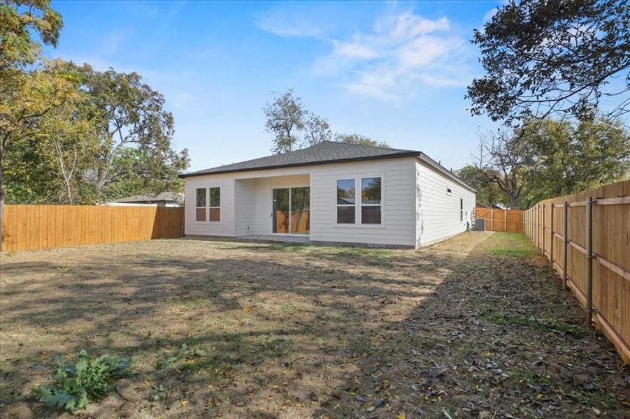 Rear view of property with a fenced backyard and a patio area