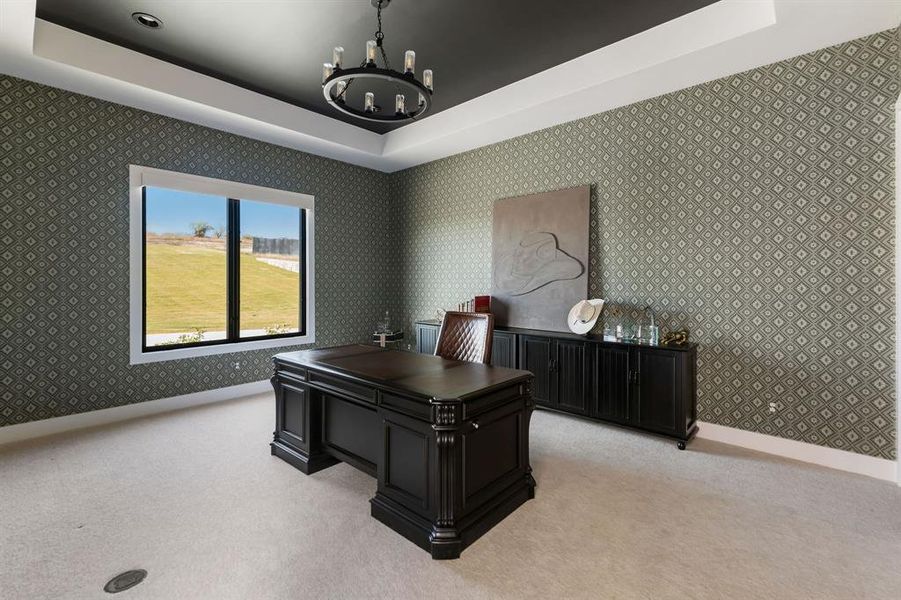 Home office featuring a tray ceiling, a chandelier, wallpapered walls, and light colored carpet Home office featuring a tray ceiling, a chandelier, wallpapered walls, and light colored carpet