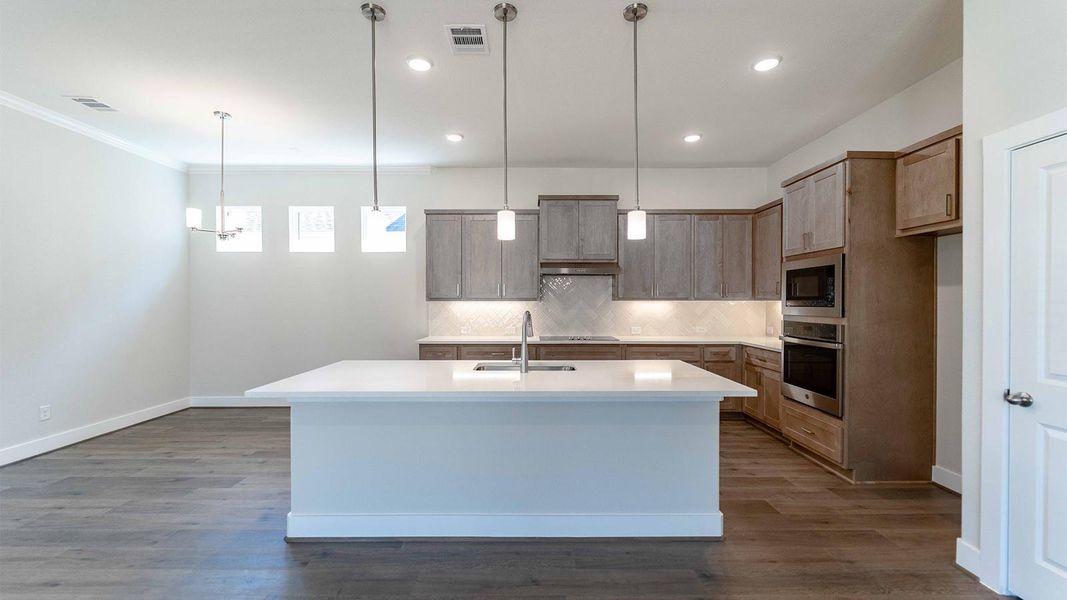 Kitchen with hanging light fixtures, tasteful backsplash, stainless steel appliances, dark wood-style floors, and recessed lighting Kitchen with hanging light fixtures, tasteful backsplash, stainless steel appliances, dark wood-style floors, and recessed lighting