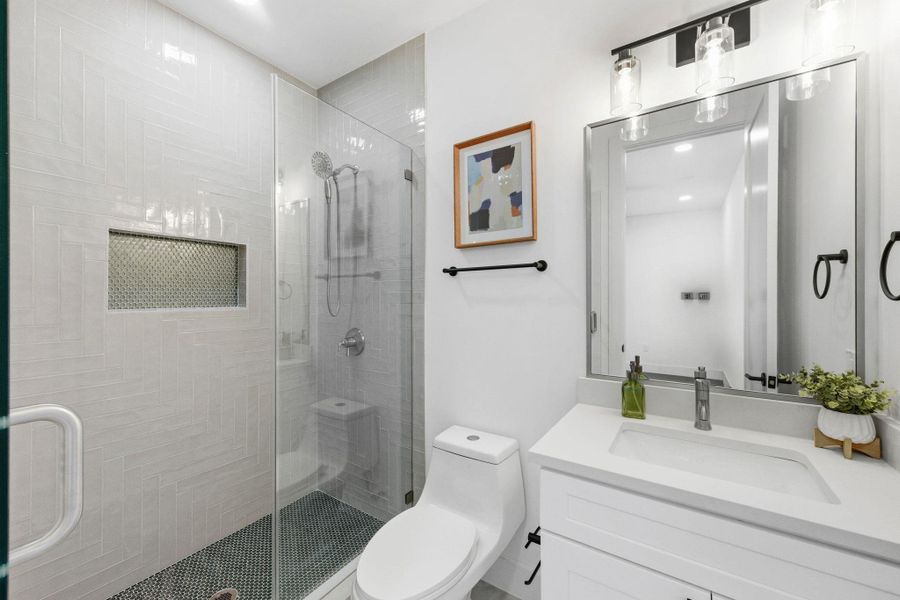 Ensuite full bathroom with a shower stall, vanity, and recessed lighting