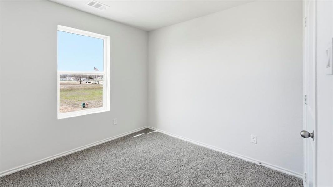Spare room featuring carpet and baseboards