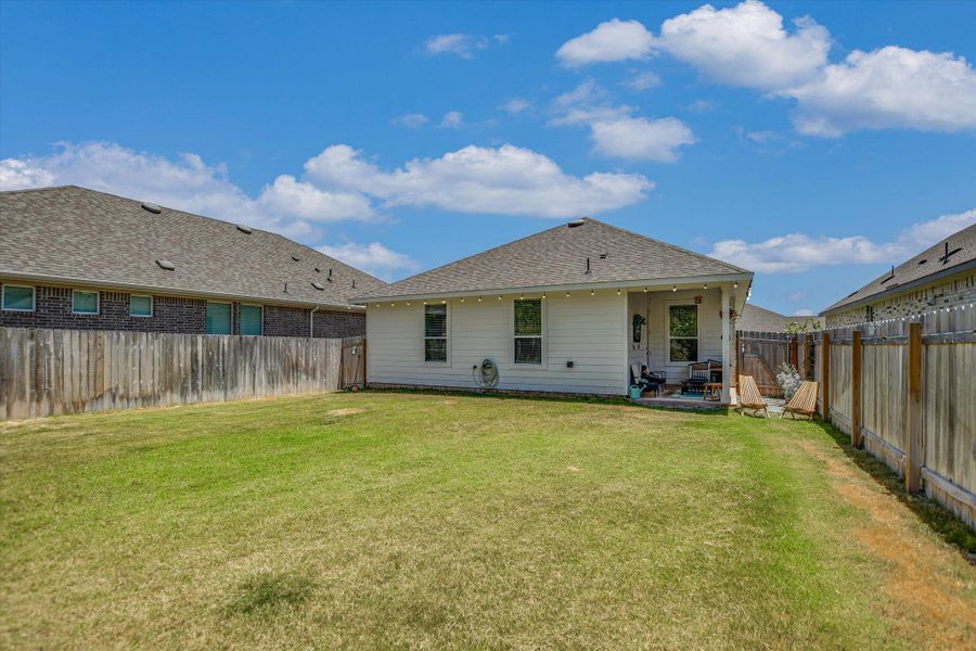 A well-maintained fenced backyard offers ample green space and a covered patio for outdoor enjoyment. A well-maintained fenced backyard offers ample green space and a covered patio for outdoor enjoyment.