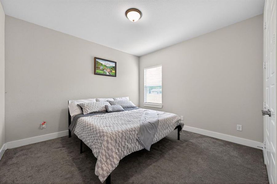 This room features neutral-toned walls, a window with blinds, and carpeting