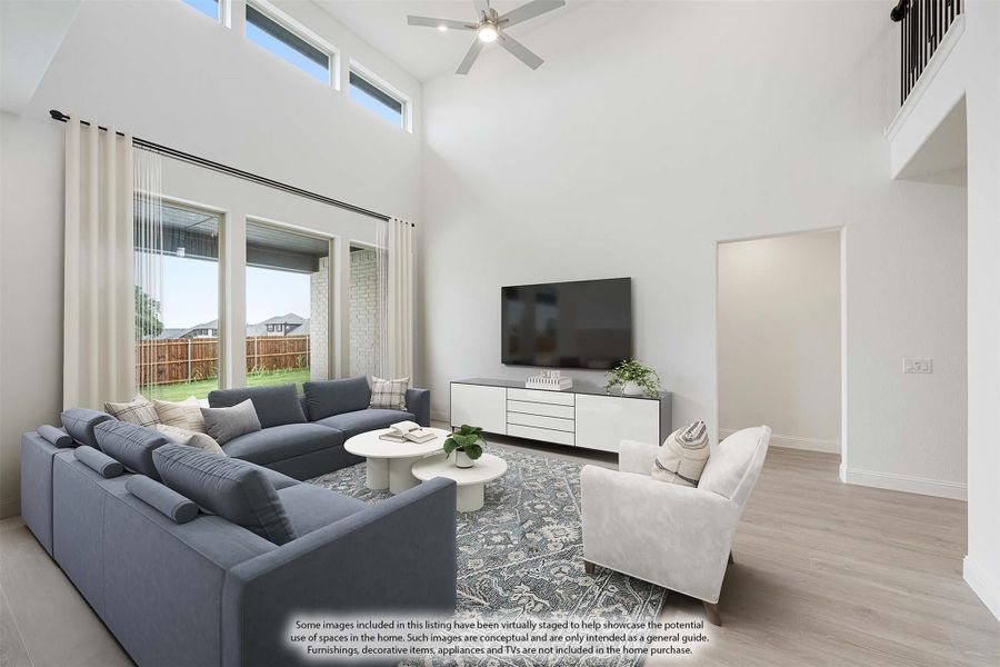 Living room with two-story ceiling, ceiling fan, large windows, and light wood floors Living room with two-story ceiling, ceiling fan, large windows, and light wood floors