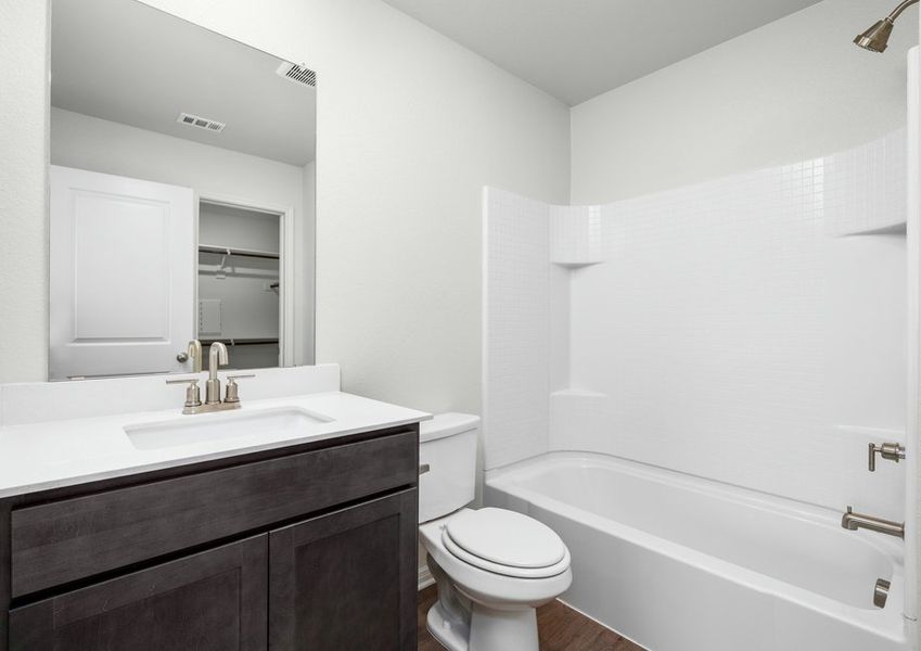 The master bathroom has a great vanity space and shower-tub combo.