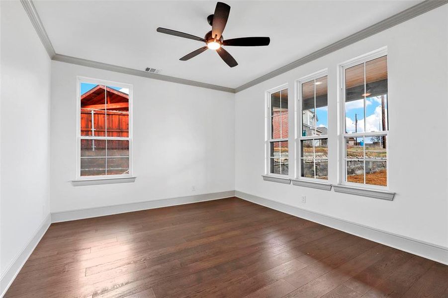 Unfurnished room with crown molding, ceiling fan, and dark hardwood / wood-style flooring