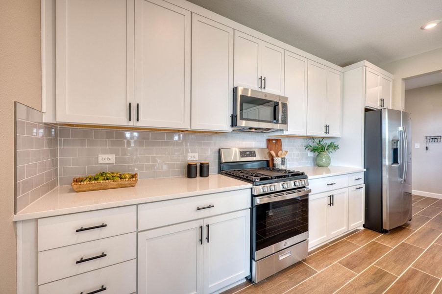Elegant stone countertops and timeless tile backsplashes define this beautifully updated cooking space. Elegant stone countertops and timeless tile backsplashes define this beautifully updated cooking space.