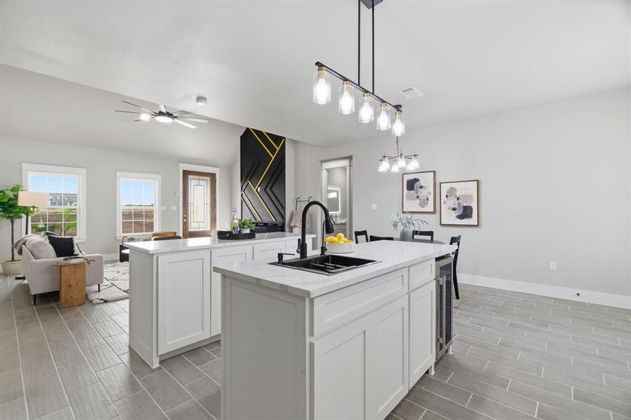 Kitchen with open floor plan, white cabinets, decorative light fixtures, light stone countertops, and wood tiled floors