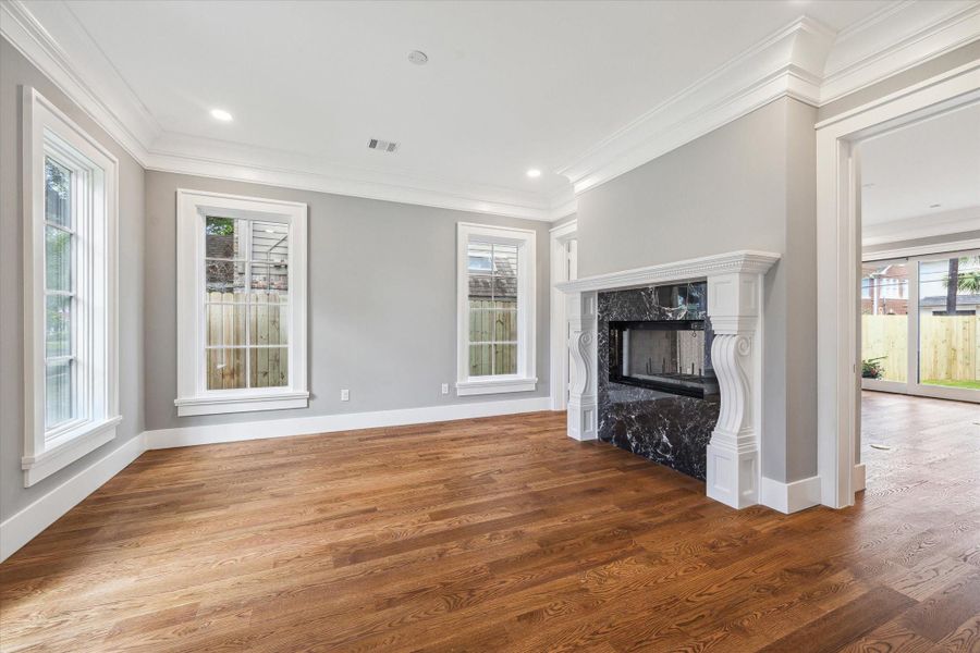 A view of the living room/study that features the outstanding double sided fireplace flanked by doors that can be closed for privacy.  Lovely large windows provide light on 2 walls.