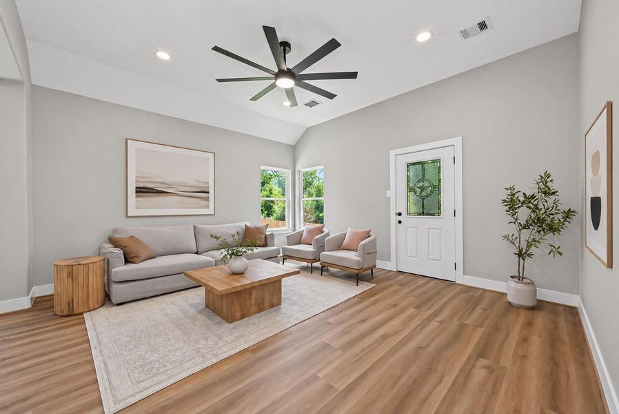 Spacious living area with high ceilings and abundant natural light, overlooking the large backyard—perfect for relaxing or entertaining.