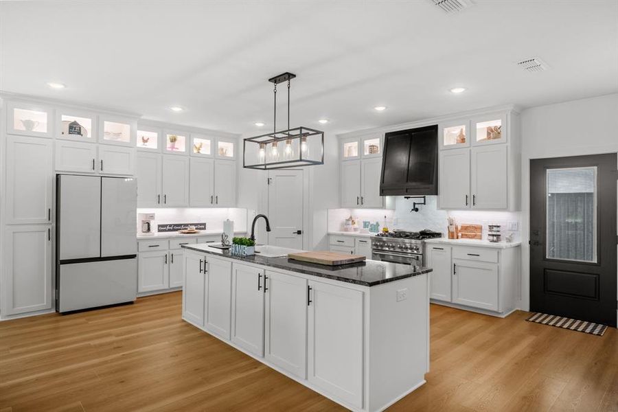 Kitchen featuring stainless steel appliances, light wood-style flooring, white cabinets, and recessed lighting Kitchen featuring stainless steel appliances, light wood-style flooring, white cabinets, and recessed lighting