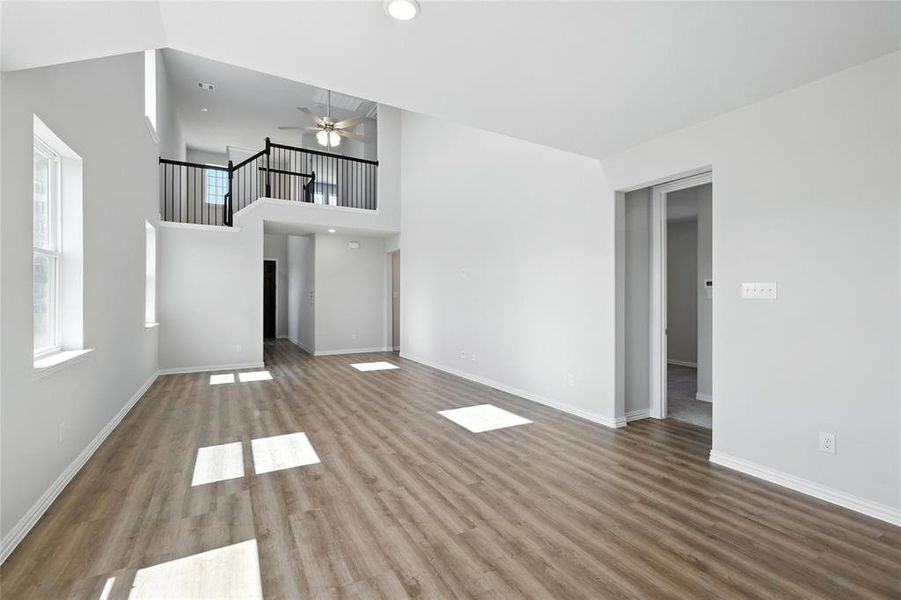 Unfurnished living room featuring wood finished floors and ceiling fan Unfurnished living room featuring wood finished floors and ceiling fan