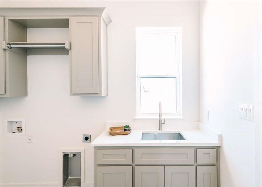 Laundry area featuring washer hookup, cabinets, sink, and electric dryer hookup