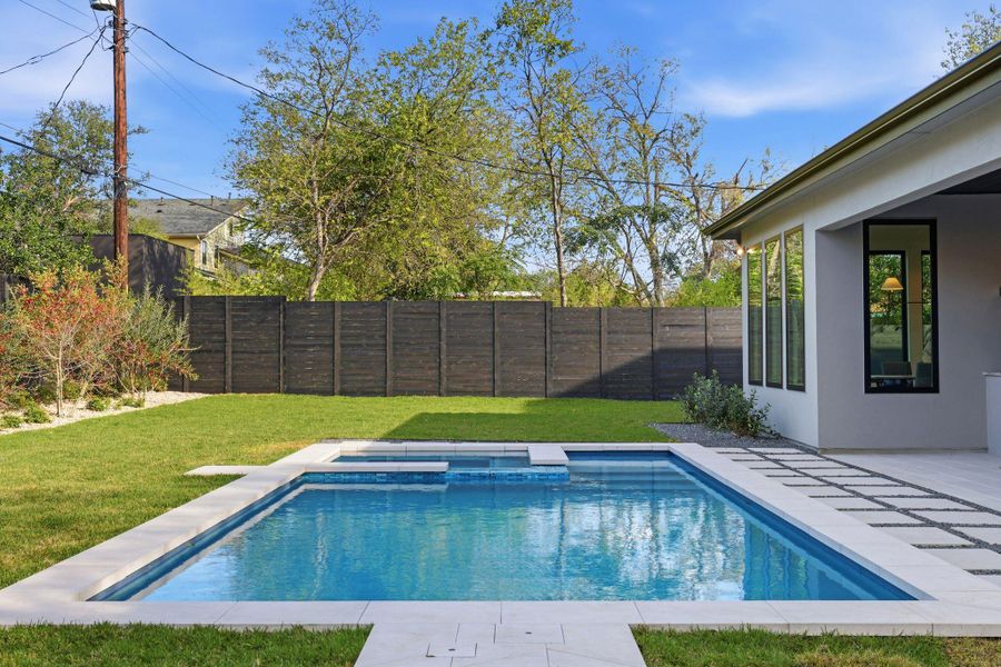 View of swimming pool featuring a patio area, a fenced backyard, and a pool with connected hot tub View of swimming pool featuring a patio area, a fenced backyard, and a pool with connected hot tub