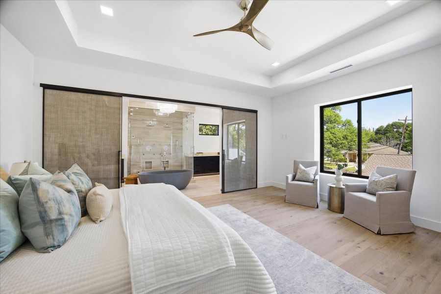 Natural light pours through oversized windows, creating a bright, airy atmosphere while maintaining a sense of privacy and calm.