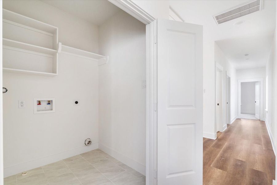 Heading upstairs, the stairs and second floor feature Luxury Vinyl Flooring, 9 ft ceilings, and double shaker-style doors. Convenient laundry room with washer and dryer connections, built-in shelving, and easy access off the main hallway. Heading upstairs, the stairs and second floor feature Luxury Vinyl Flooring, 9 ft ceilings, and double shaker-style doors. Convenient laundry room with washer and dryer connections, built-in shelving, and easy access off the main hallway.