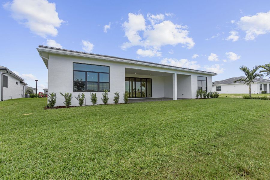 Front exterior of a new home in Astor Creek Golf & Country Club, Port St. Lucie, FL, highlighting curb appeal (Image 21).