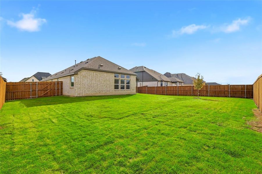 Rear view of property with brick siding and a fenced backyard Rear view of property with brick siding and a fenced backyard