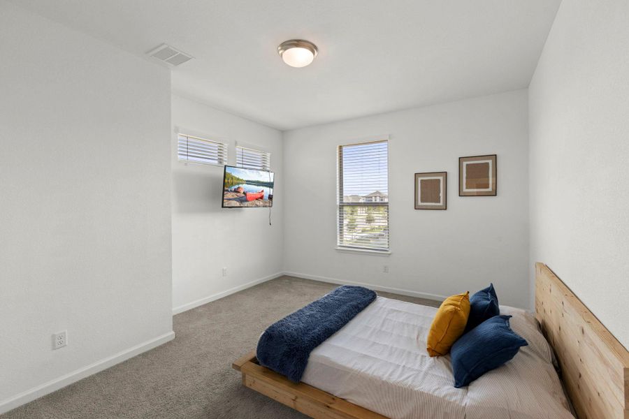 Crisp walls and plush carpeting frame this peaceful sleeping space with abundant natural light.