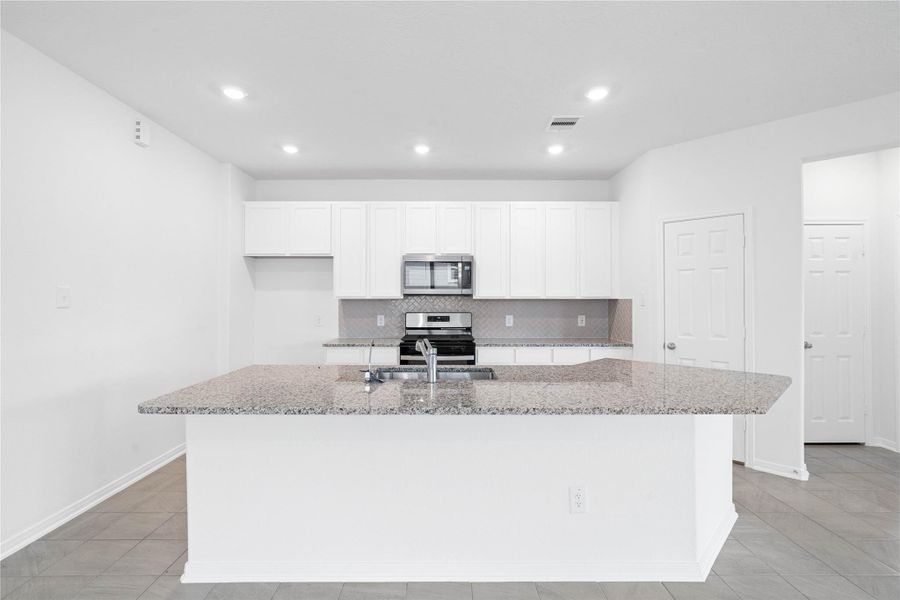 This spacious kitchen has it all—ample storage, generous counter space, and a layout that truly makes it the heart of the home.