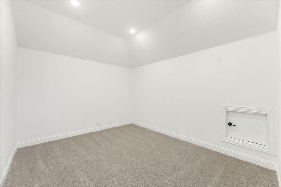 Empty room with white walls, gray carpet, recessed lighting, and small access panel on wall Empty room with white walls, gray carpet, recessed lighting, and small access panel on wall