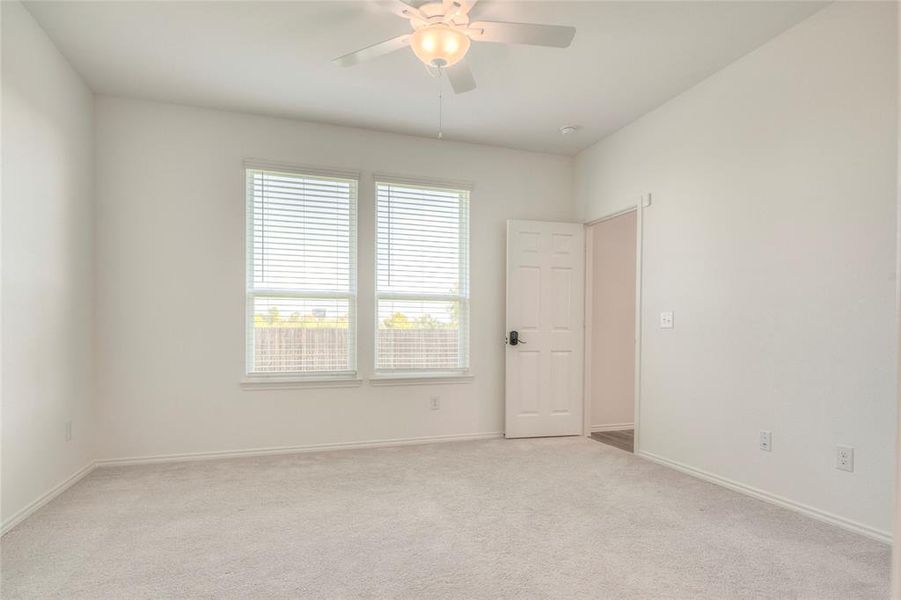 Unfurnished room featuring light colored carpet and ceiling fan Unfurnished room featuring light colored carpet and ceiling fan