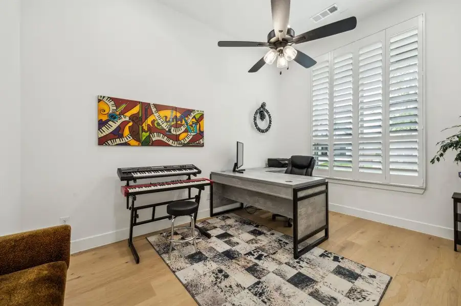 Office space featuring baseboards, wood finished floors, and ceiling fan