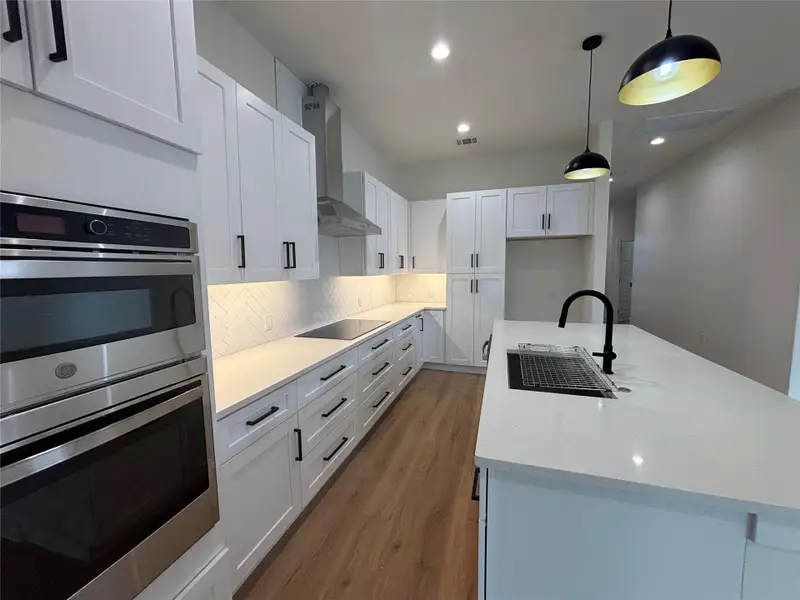Culinary creations come to life in this kitchen, featuring an expansive island, sleek appliances, and ample cabinet storage. Culinary creations come to life in this kitchen, featuring an expansive island, sleek appliances, and ample cabinet storage.