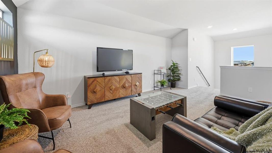 Carpeted living area with vaulted ceiling and baseboards Carpeted living area with vaulted ceiling and baseboards