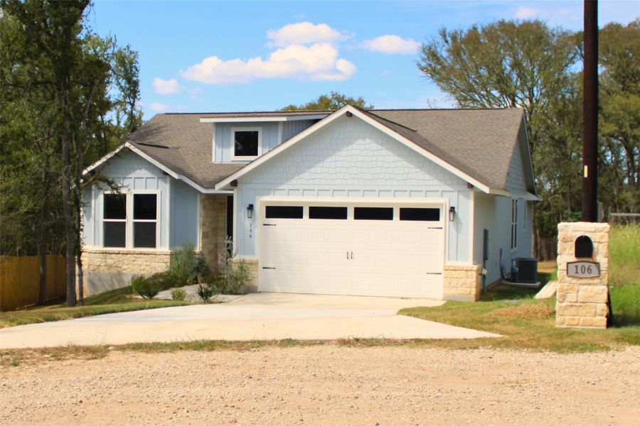 Single-story residence featuring light blue siding with shaker accents and stone veneer details