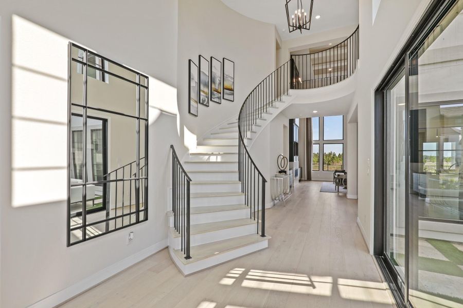 An elegant curved staircase across from the interior courtyard. Representational image.