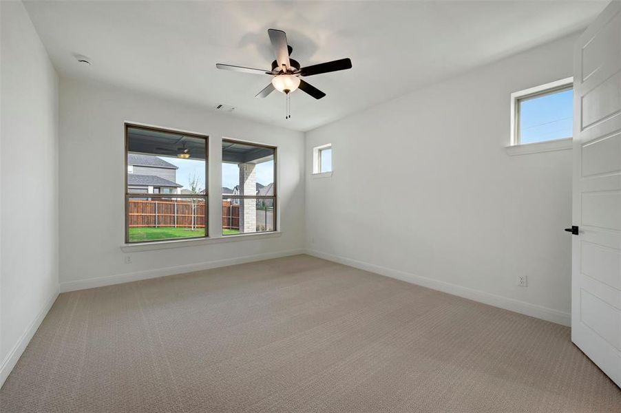 Spare room featuring light colored carpet, healthy amount of natural light, and ceiling fan