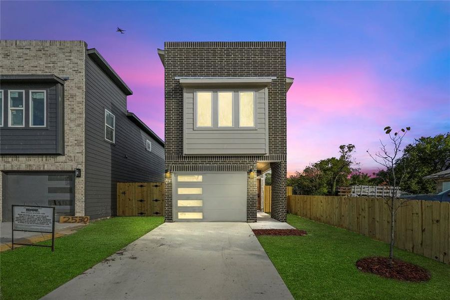 View of front facade with a lawn and a garage