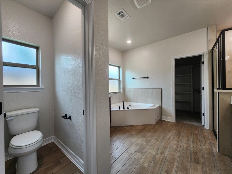 Relax and refresh in this generously proportioned primary bath, boasting a spacious tub and sleek flooring. Relax and refresh in this generously proportioned primary bath, boasting a spacious tub and sleek flooring.