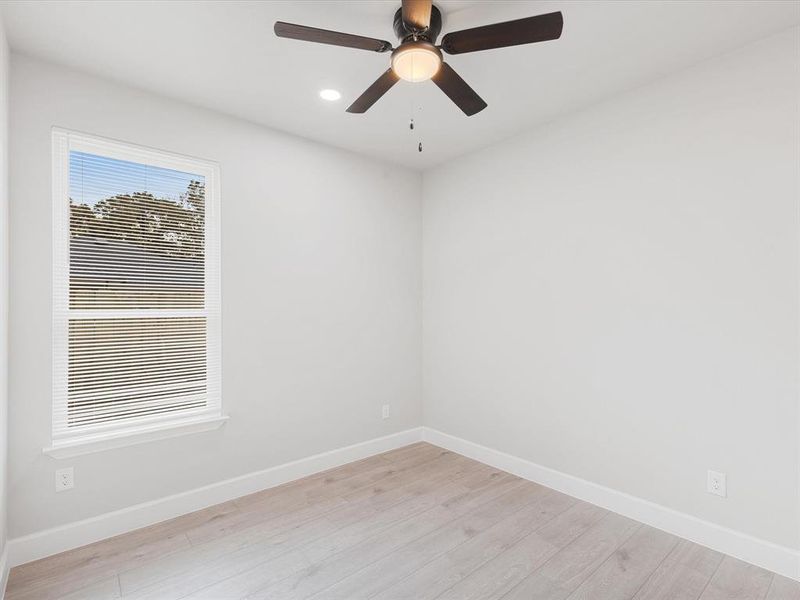Unfurnished room featuring light wood-style flooring, a ceiling fan, and recessed lighting