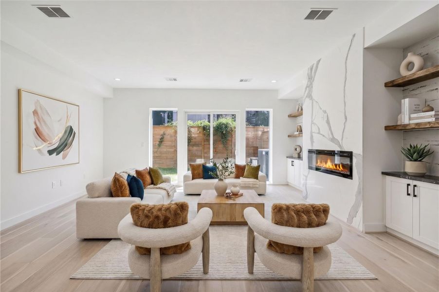Living Room – Located on the first floor, this inviting space features double French doors opening to the backyard, filling the room with beautiful natural light, along with custom built-ins (virtal staging)