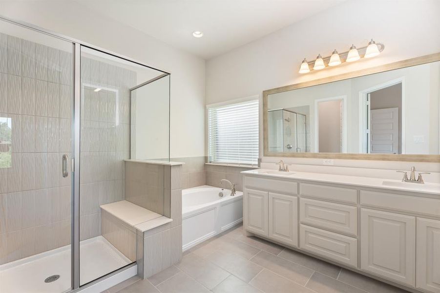 Full bath featuring a shower stall, a garden tub, double vanity, light tile patterned floors, and recessed lighting
