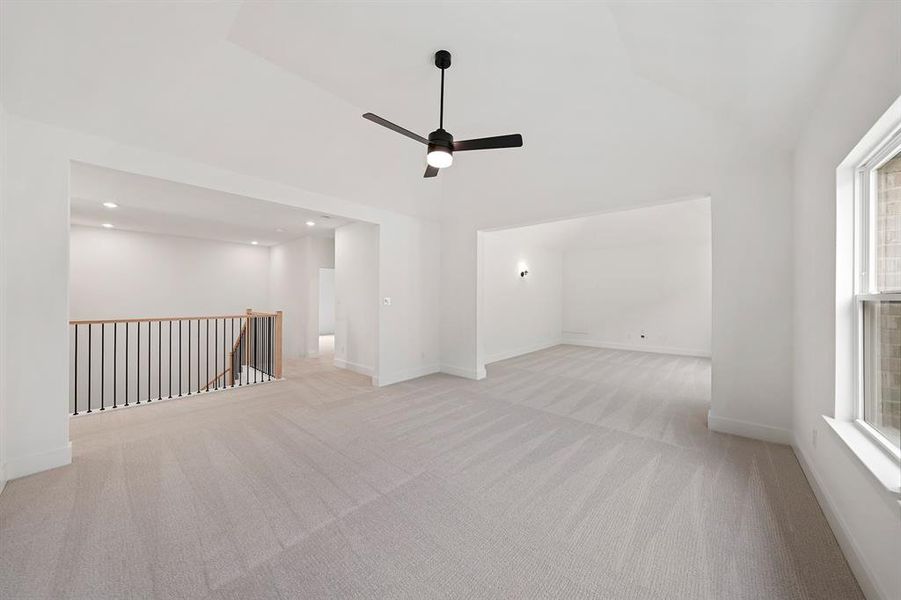 Empty room with light carpet, lofted ceiling, ceiling fan, and recessed lighting Empty room with light carpet, lofted ceiling, ceiling fan, and recessed lighting