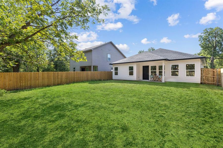 Back of house with a huge fenced backyard, a patio area.