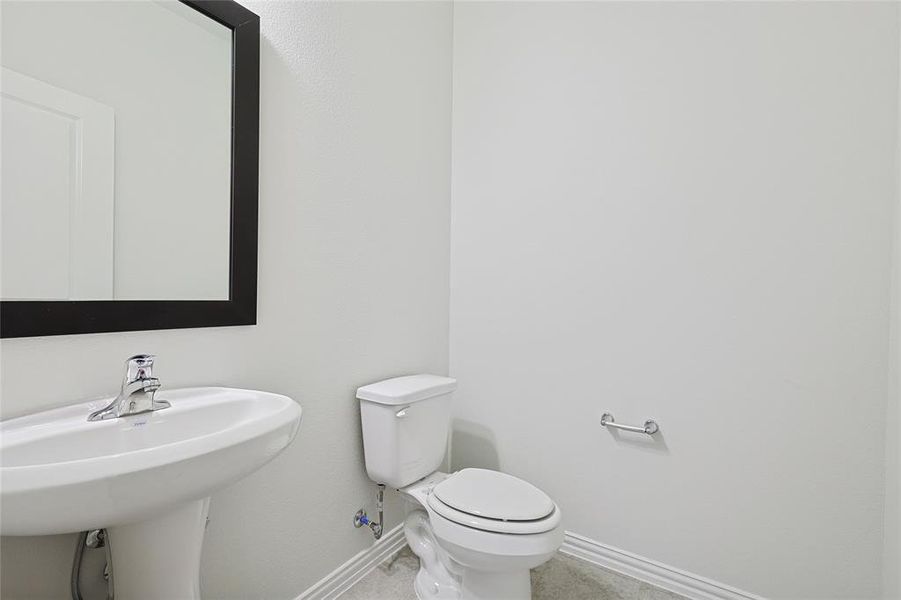 Half bath with toilet and baseboards