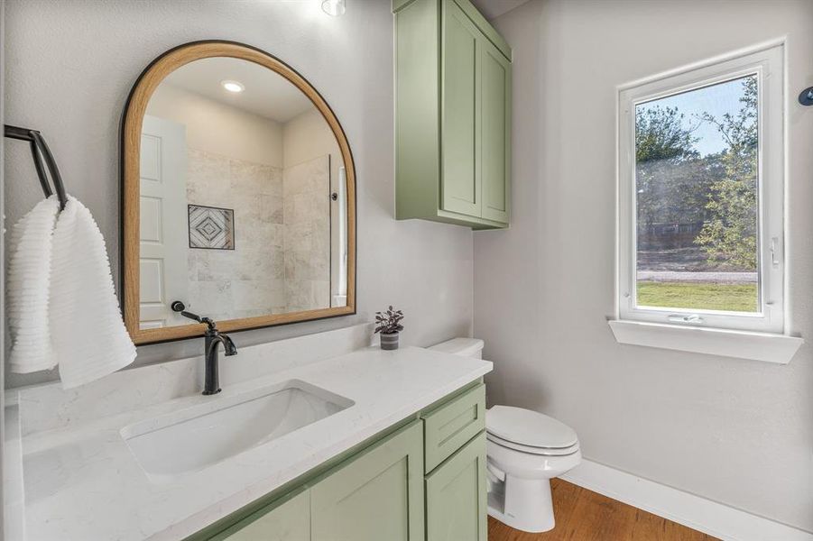 Full bathroom with vanity, wood finished floors, and healthy amount of natural light Full bathroom with vanity, wood finished floors, and healthy amount of natural light