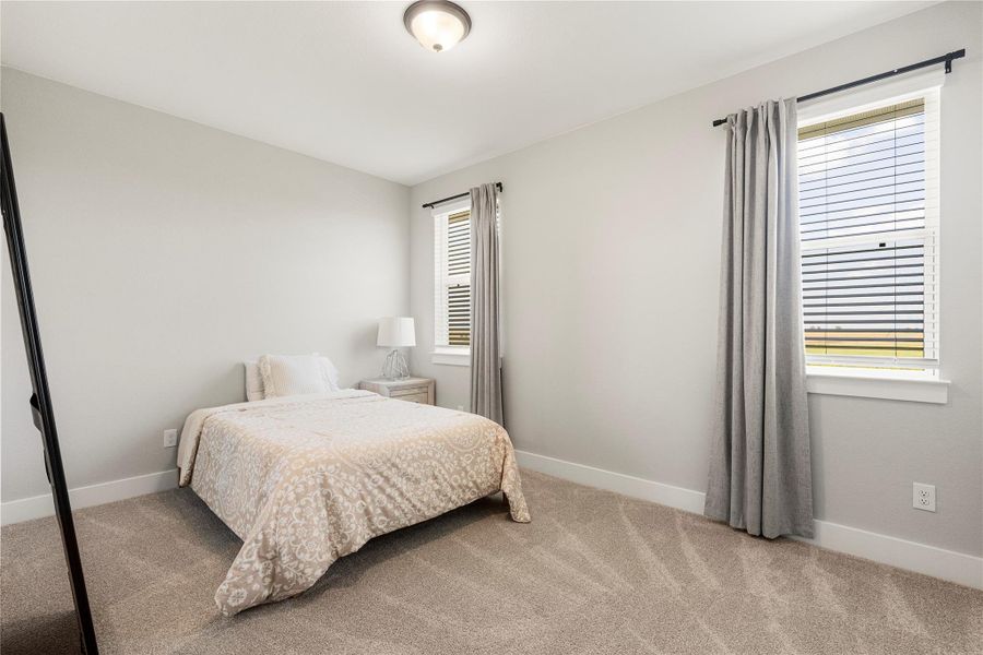 A cozy bedroom with soft carpet and natural illumination, perfect for peaceful slumber. A cozy bedroom with soft carpet and natural illumination, perfect for peaceful slumber.